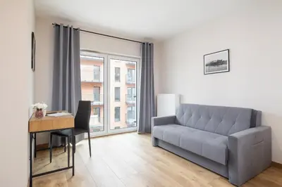 a living room with a couch and a desk at Modern Apartment Podgorze with Parking by Noclegi Renters in Kraków