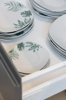 a stack of plates and bowls in a drawer at Modern Apartment Podgorze with Parking by Noclegi Renters in Kraków