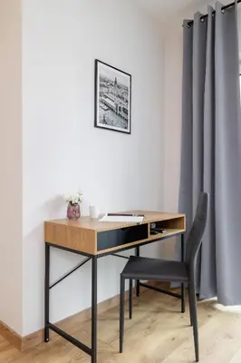 a desk with a chair next to a wall at Modern Apartment Podgorze with Parking by Noclegi Renters in Kraków