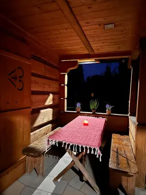 a wooden cabin with a table and a window at Pod Gwiazdami in Dąbrówka