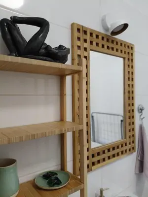 a bathroom with wooden shelves and a mirror at Parrot's Apartment in Kraków