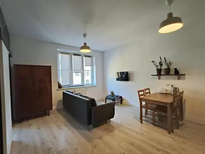 a living room with a couch and a table at Parrot's Apartment in Kraków