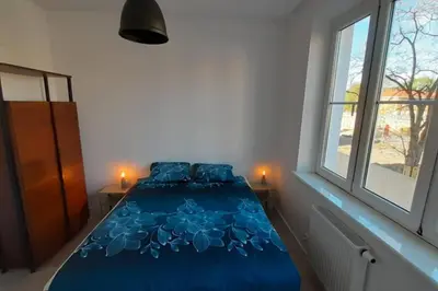 a blue bed in a room with a window at Parrot's Apartment in Kraków