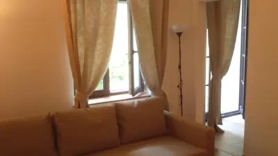 a bed in a room with a lamp and curtains at Words & Swords in Kraków