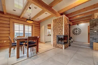 a dining room with a table and a fireplace at Domek w Górach z Balią in Zawoja