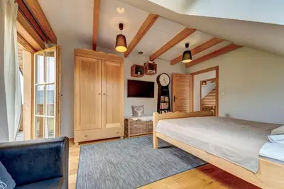a bedroom with a large bed and a tv at Domek w Górach z Balią in Zawoja