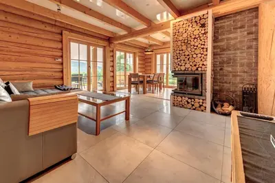 a living room with a fireplace in a log cabin at Domek w Górach z Balią in Zawoja