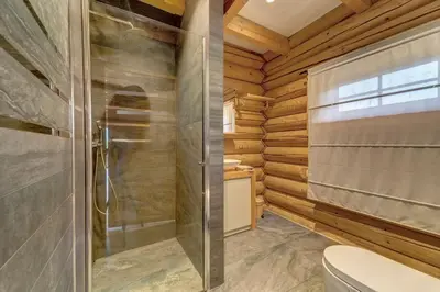 a bathroom with a toilet and a glass shower at Domek w Górach z Balią in Zawoja