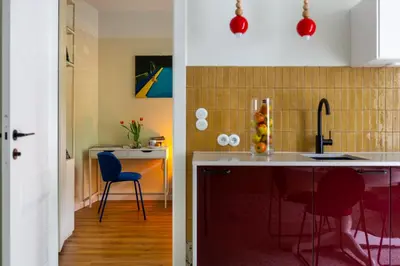 a kitchen with a sink and a counter with chairs at Canvas House Fragola Apartments - heart of Kazimierz in Kraków