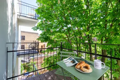 a table with a plate of pastries on a balcony at Canvas House Fragola Apartments - heart of Kazimierz in Kraków
