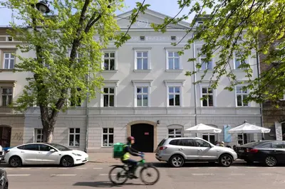 a person riding a bike in front of a building at Canvas House Fragola Apartments - heart of Kazimierz in Kraków