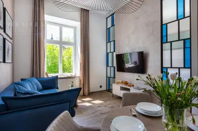 a living room with a blue couch and a table at Canvas House Fragola Apartments - heart of Kazimierz in Kraków