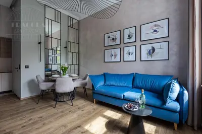 a living room with a blue couch and a table at Canvas House Fragola Apartments - heart of Kazimierz in Kraków