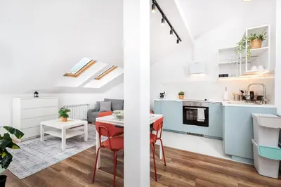 a kitchen and a living room with a table and chairs at Kraków Trailside Apartments - by Upstairs in Kraków
