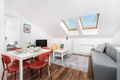a living room with a table and a couch at Kraków Trailside Apartments - by Upstairs in Kraków