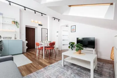a living room with a couch and a table at Kraków Trailside Apartments - by Upstairs in Kraków
