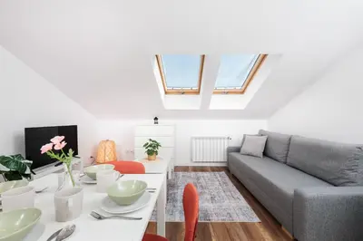 a living room with a table and a couch at Kraków Trailside Apartments - by Upstairs in Kraków