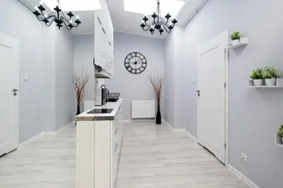 a kitchen with white walls and a hallway with white counters at Długa 14 by Homeprime in Kraków