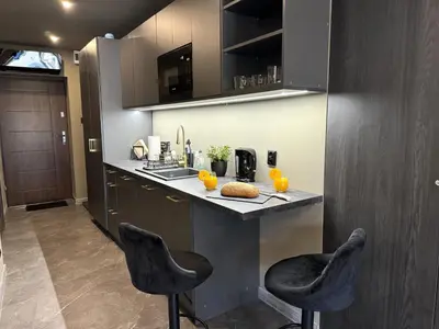 a kitchen with two bar stools at a counter at City Center Studio with a View in Kraków