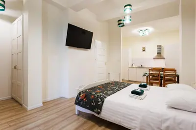 a bedroom with a bed and a tv on a wall at City of the Kings-Edith in Kraków