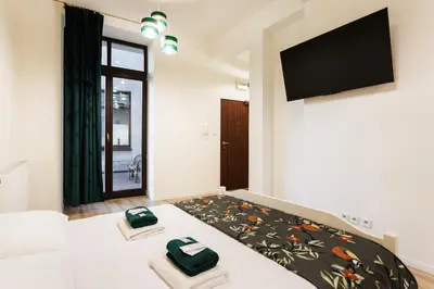 a bedroom with a bed and a flat screen tv at City of the Kings-Edith in Kraków