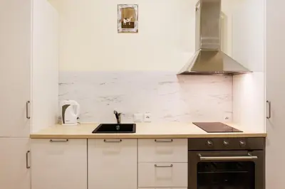 a kitchen with white cabinets and a sink at City of the Kings-Edith in Kraków