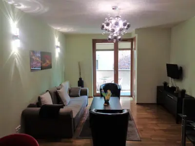 a living room with a couch and a chandelier at Angel Plaza Krakow in Kraków