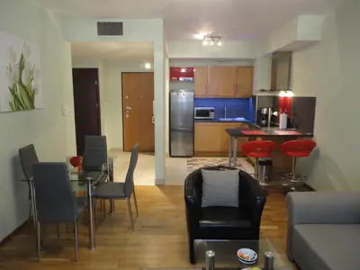 a living room with a table and chairs and a kitchen at Angel Plaza Krakow in Kraków
