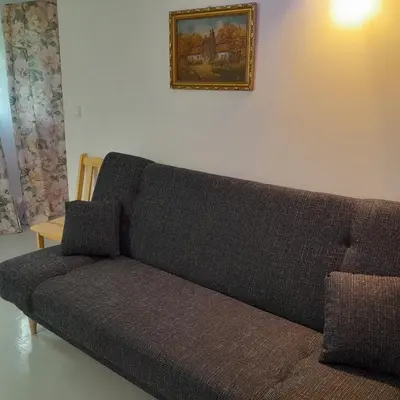 a couch in a living room with a picture on the wall at Domek Muchomorek 1km od Energylandii in Zator