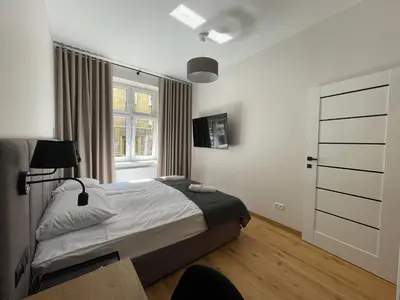 a bedroom with a bed and a window at Revesen Premium Apartments in Kraków