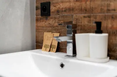 a white bathroom sink with a soap dispenser on it at Revesen Premium Apartments in Kraków