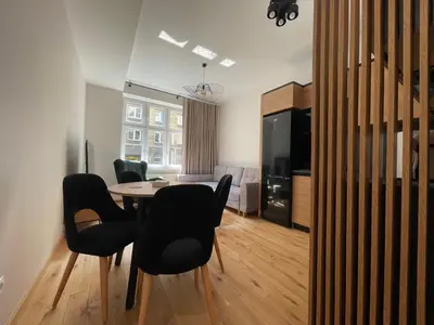 a living room with a dining room table and chairs at Revesen Premium Apartments in Kraków