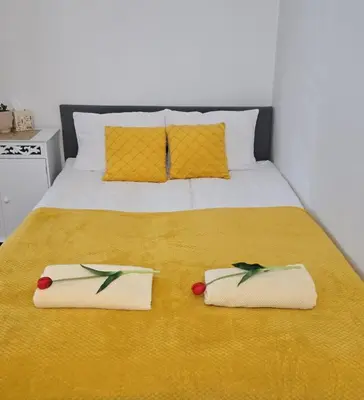 a bed with two towels on top of it at ViP APART CRACOW in Kraków