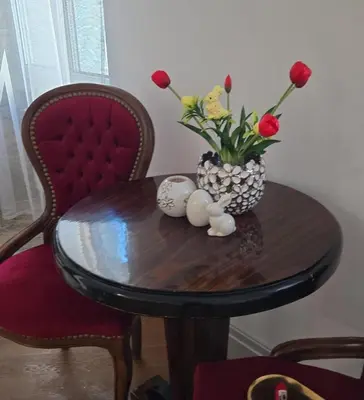 a wooden table with a vase of flowers on it at ViP APART CRACOW in Kraków