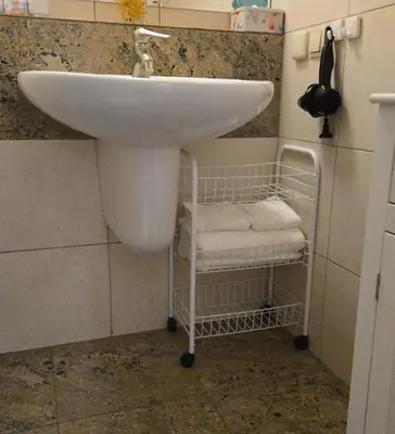 a bathroom sink with a towel rack under it at ViP APART CRACOW in Kraków