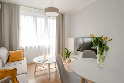 a white living room with a white table and a white couch at Quiet Courtyard Apartment near Old Town in Kraków
