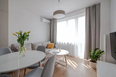 a white living room with a white table and chairs at Quiet Courtyard Apartment near Old Town in Kraków