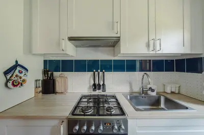 a kitchen with white cabinets and a stove and a sink at Willa Juszczyn in Juszczyn