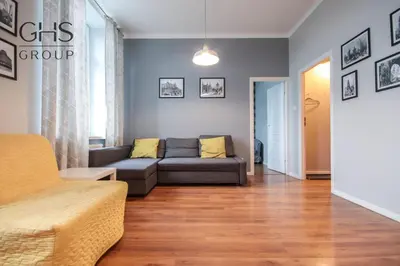 a living room with a couch and wooden floors at Stylowy apartament w samym centrum Krakowa in Kraków