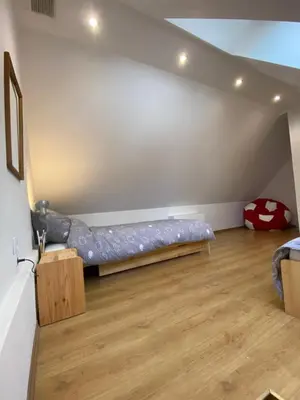 a bedroom with a bed in the corner of a room at Beskidzka Apartments in Sucha Beskidzka