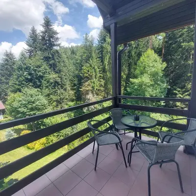 a porch with two chairs and a table with a view at Beskidzka Apartments in Sucha Beskidzka