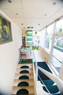 a room with a staircase with a table and chairs at Akacja Pokoje Gościnne in Kraków
