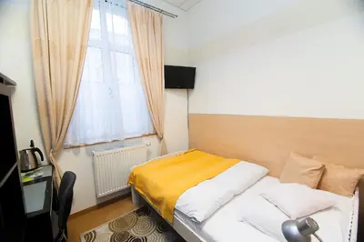 a small bedroom with a bed and a window at Akacja Pokoje Gościnne in Kraków