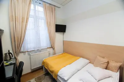 a small bedroom with a bed and a window at Akacja Pokoje Gościnne in Kraków