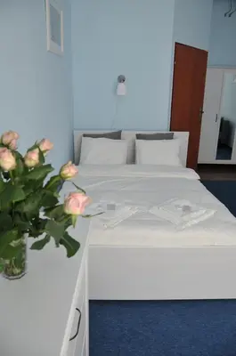 a bedroom with two beds and a vase of flowers at Vinci in Kraków