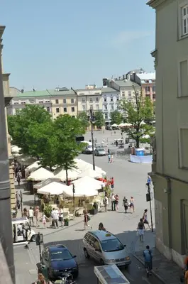 a group of people walking around a street with umbrellas at Vinci in Kraków