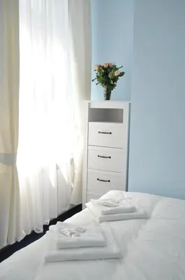 a bedroom with a dresser with towels on a bed at Vinci in Kraków