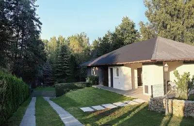 a small white building with a grass yard at Apartament Zacisze in Wieliczka