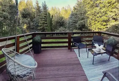 a porch with chairs and a swing and a table at Apartament Zacisze in Wieliczka