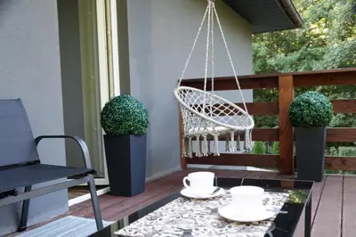 a porch with a swing and a coffee table at Apartament Zacisze in Wieliczka